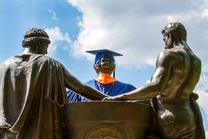 Alma Mater, from the back, wearing commencement regalia